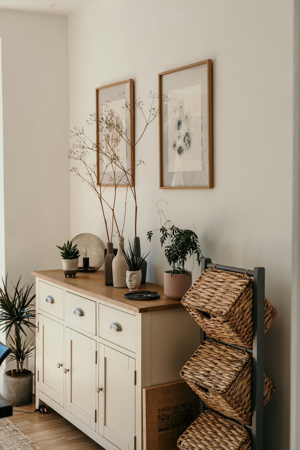 Cream sideboard with an oak top, plants and framed prints