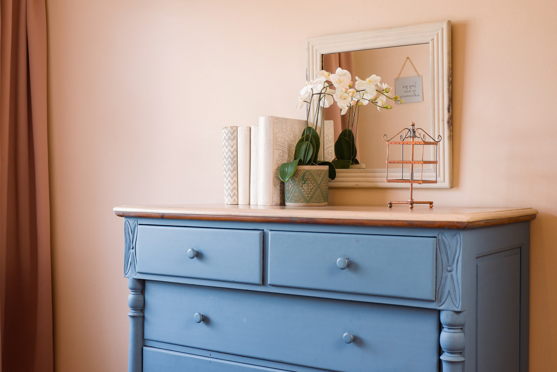 Restored blue painted dresser with orchids and a pale mirror