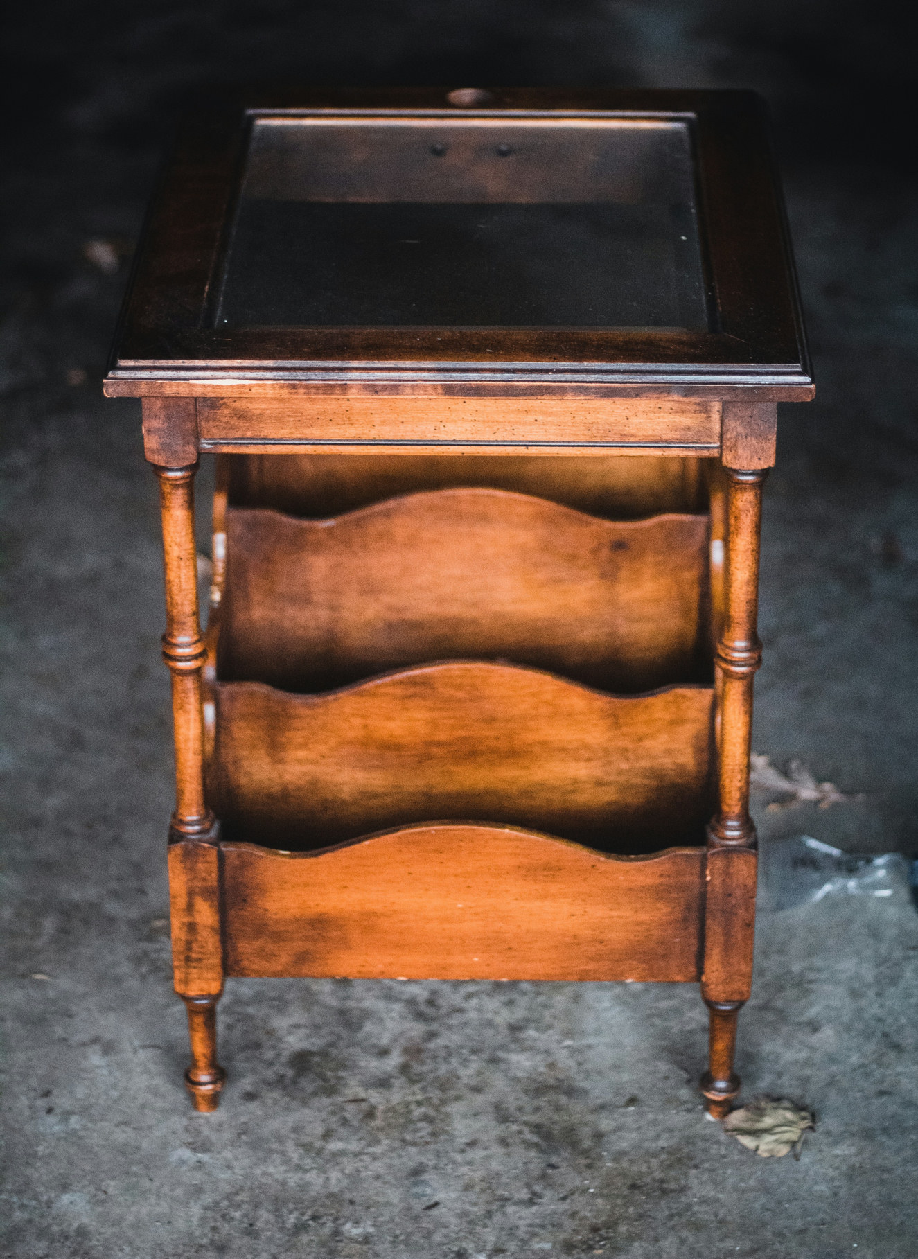 Wooden side table with a glass top and magazine shelves