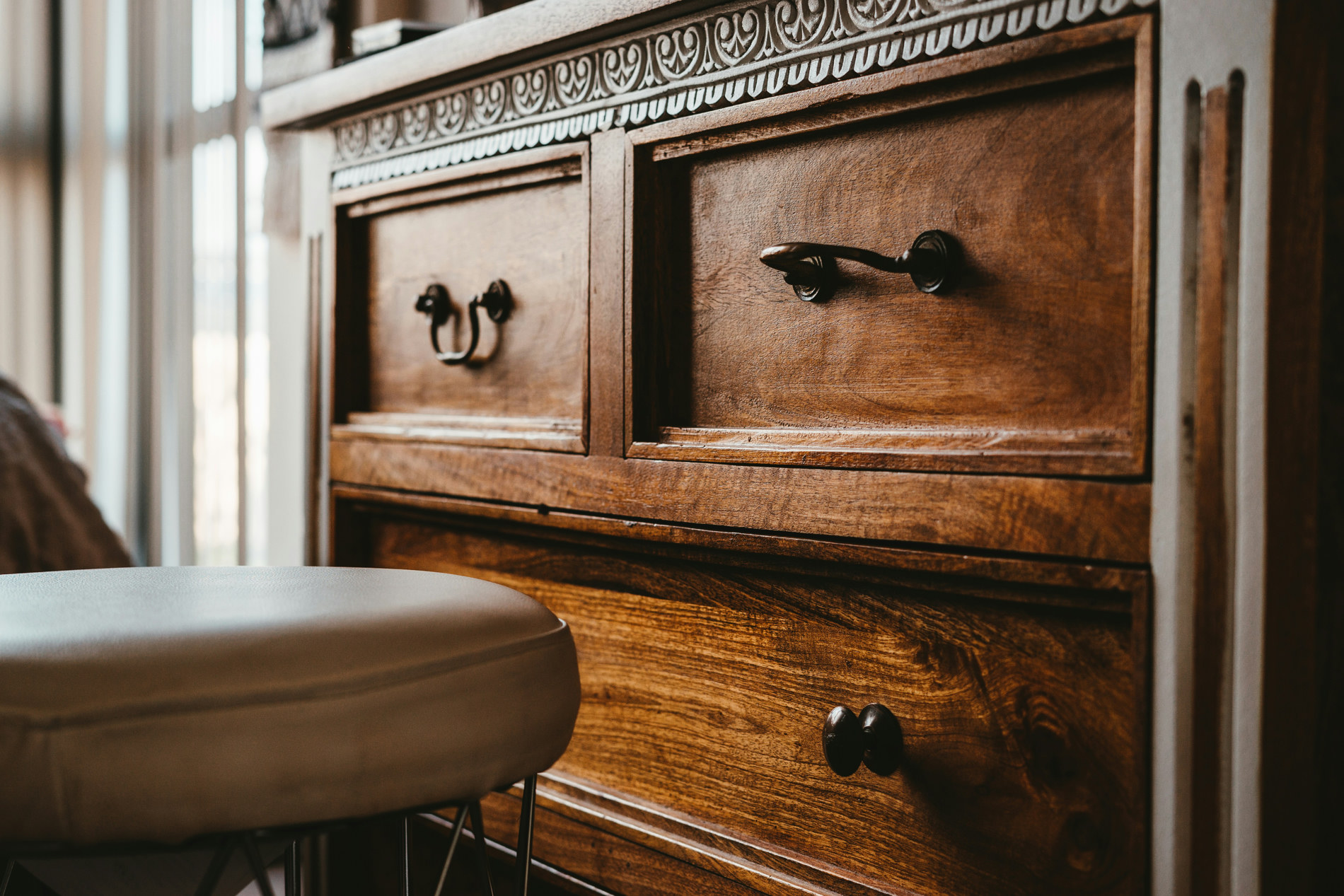 Carved wooden dresser with dark metal handles